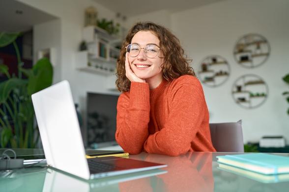 Smiling, happy woman in front of a laptop