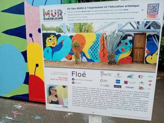 Paneau d'information sur l'artiste et le Mur de Guadeloupe, que vous pouvez suivre sur instagram @floe.arts et @lemurguadeloupe respectivement.
Extrait choisis: « Floé, Street-Artiste depuis douze ans dessine des femmes puissantes et généreuses, aux facettes multiples, à la fois fragiles et fortes, disgracieuses et sexy, farouches et provocantes, gaies et tortuées... Voir la beauté jaillir  de ce qui est généralement considéré comme "moche."
