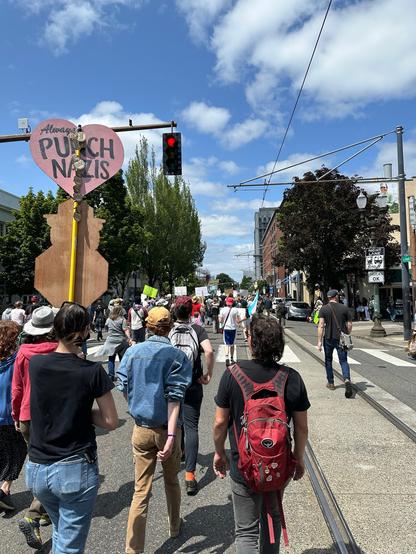 Large group of protestors marching up SE Grand Ave to the Morrison Bridge. "Always Punch Nazis" is written on a heart-shaped protest sign