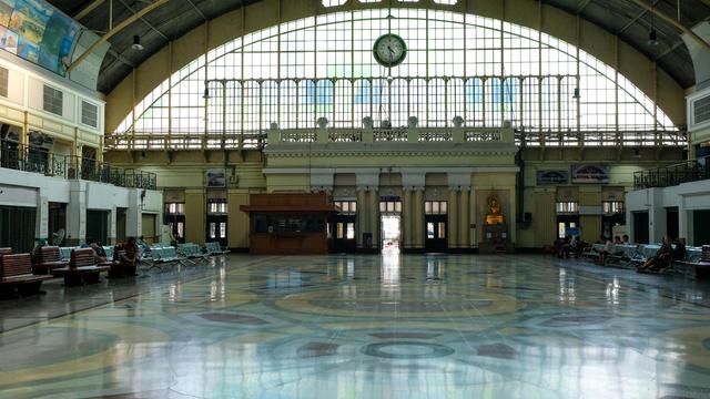 Interior of the train station with granite painted ground, glass window facade, arch shape roof, with seats on both sides