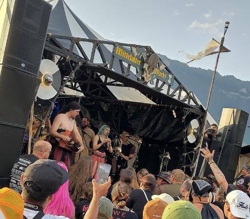 Medieval band on stage with a crowd in front.