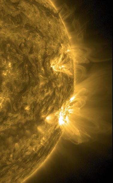 Der rechte Teil der Sonne in gelber Farbe. Die seit Tagen sichtbare Aktive Region ist inzwischen infolge der Sonnenrotation hier an den Rand gewandert. Sie ist auf der Zeigerposition zwischen drei und vier Uhr als gleißend heller Fleck abgebildet, von dem Strahlen weit ins All schießen.