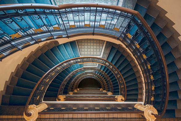 A semicircle stairwell in an old apartment building in Prague straight from the top perspective 6 floors down