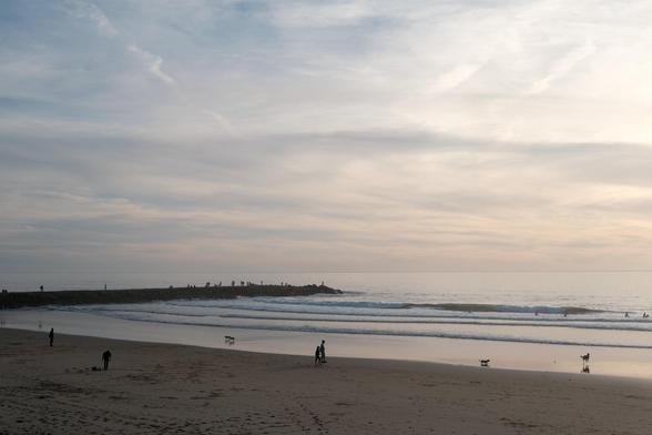 View of the beach at dusk, on a calm and sunny day.
