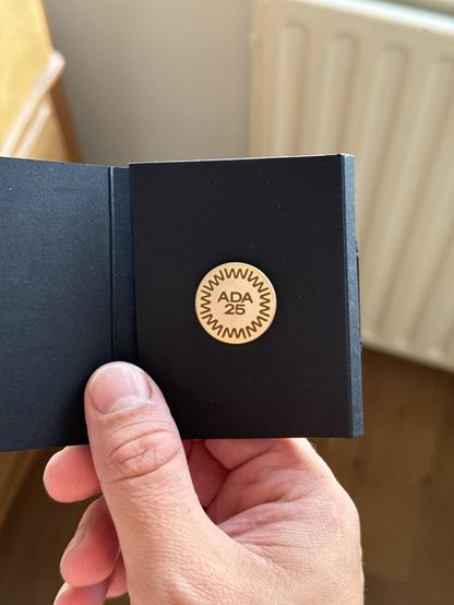 Photo of a golden ADA 25 pin which all winners of the Apple Design Award received this year