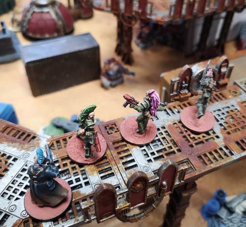 First mate and recruits survey the scrap yard from atop a gantry, and rain fire down on the approaching robot