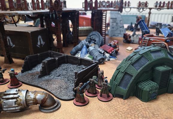 Captain leading troopers and a grenadier across the scrap yard