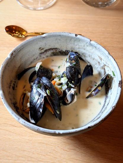 Bowl of soup with whole pieces of small black oysters