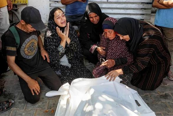 Women mourn next to the body of a person killed in an Israeli attack near a food distribution center in northwestern Gaza, at the Shifa Hospital, on Friday. 

Photo: AFP/OMAR AL-QATTAA