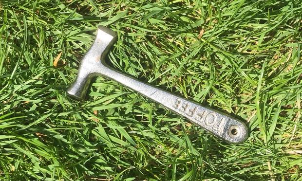 Small metal hammer lying on grass