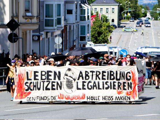Auf dem Transparent der feministischen Demonstration, zu lesen ist Leben schützen Abtreibung legalisieren / den Fundis die Hölle heiss machen.