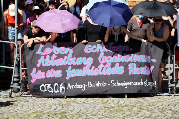 Am Ort der Abschlusskundgebung des Schweigemarschs fand auch eine Zwischenkundgebung der feministischen Demonstration statt. Es wurden Transparente gezeigt auf denen stand "Leben schützen, Abtreibung legalisieren - für eine feministische Praxis!"