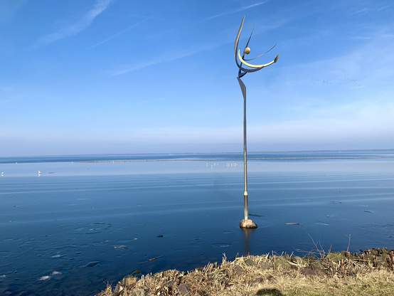 Tanz der Winde, eine Edelstahlskulptur im Wasser des Steinhuder Meeres. Blauer Himmel und Wasser, Februar 2025.