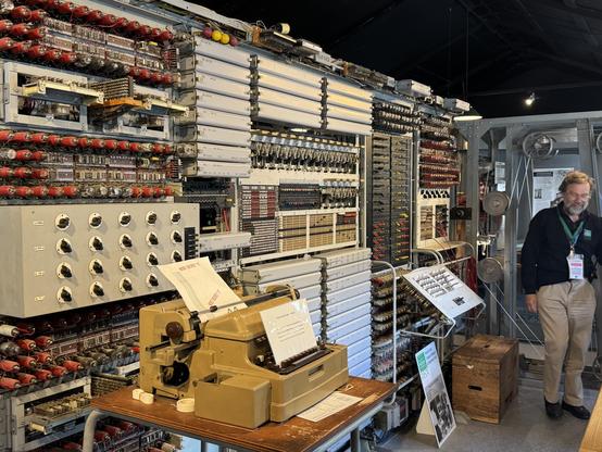 Rebuild of the Colossus computer. Many racks of valves with a teleprinter in foreground