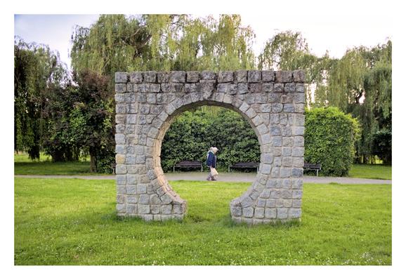 An elderly couple walks behind a circular stone structure in a park in Lubin (Poland). Their silhouettes are framed at the centre of the stone circle.
---
Una pareja de ancianos pasa por detras de una construcción circular de piedra en un parque de Lubin (Polonia). Sus siluetas quedan enmarcadas en el centro del círculo de piedra.