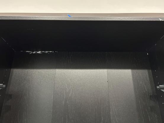 Interior joint of the IKEA BILLY bookcase showing dried silicone caulk smeared over the back wall.