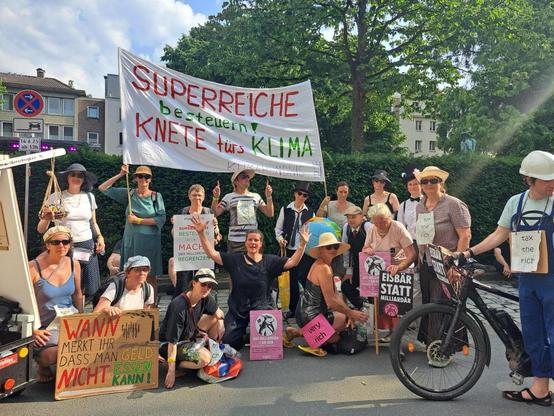 Ein Gruppenfoto mit dem Banner "Superreiche besteuern knete fürs Klima"