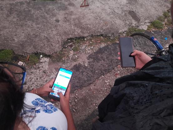 A bird's eye view of the participants mapping on their smartphones. One is seen to be using Everydoor, adding details of a shop, while another person had their screen turned off.