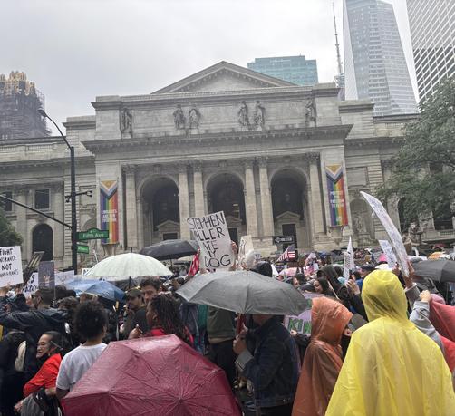 Sea of protesters and umbrellas, in front of the NYC Public Library building. It’s June, so two large pride banners are seen on either side of the facade. One reads “Protect the freedom to read” and the other “Libraries are for everyone”