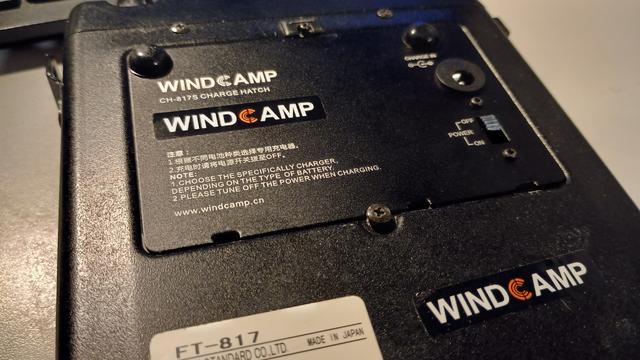 The base of an FT-817 showing the Windcamp battery cover, which replaces the original Yaesu battery cover. The new cover includes an on and off switch, and a connector for the mains charger.