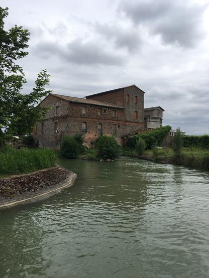 Un beau bâtiment en briques rouges au niveau d’une écluse du Canal Latéral à la Garonne