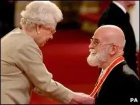 Terry Pratchett kneels before Queen Elisabeth II. The image may be from his knighthood ceremony, or possibly from his earlier OBE award.