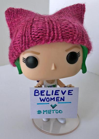 Funko Pop wearing a pink knitted pussy hat with a sign "in" her hands that reads Believe women #MeToo
