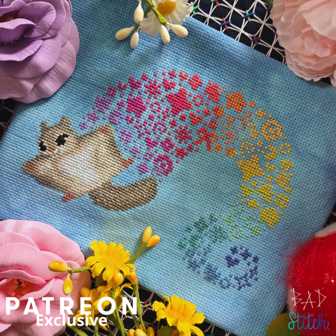 A cross stitch project of a flying squirrel leaping through the air, and a swirly mass of small starry cross stitched motifs flow behind him.  Patreon Exclusive.  BAD Stitch.