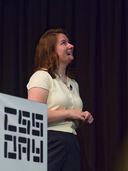 A photo of Cyd, smiling and looking at the projector screen.