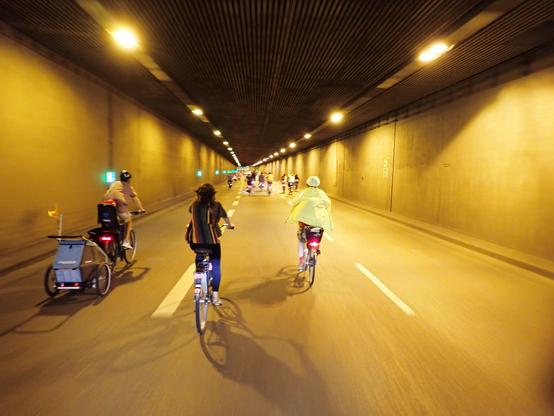 Radfahrende in beleuchtetem Tunnel.