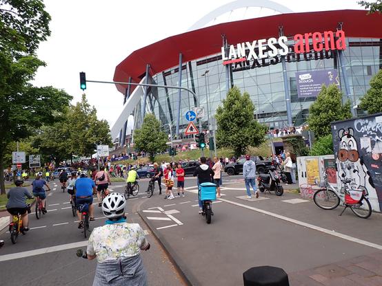 Radfahrende vor "Lanxess Arena".