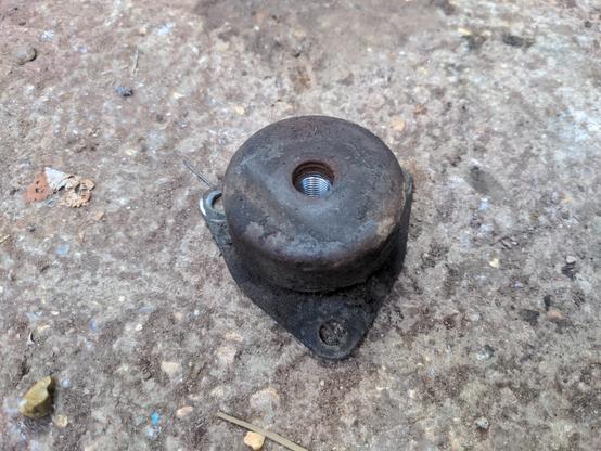 One of the original mounting bushes for the front subframe of a Rover P5. It has three bolt holes on the bottom plate where it bolts to the subframe, and on the top is a cover with a large bolt hole where the body bolts in. These two parts are isolated from each other by rubber, which is out of sight under the top cover.