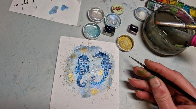 Male zwei leicht abstrahierte Seepferdchen in blau metallic Aquarellfarben