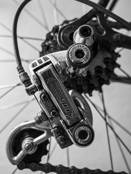 Detail picture of a bicycle showing the rear derraileur, chain, casette...