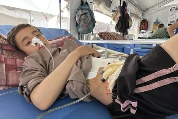 A Palestinian child rests in the Nasser Medical Complex after being shot in the abdomen by Israeli occupation forces while seeking food at a Gaza Humanitarian Foundation “death trap.” Moaz Abu TahaSIPA/Newscom