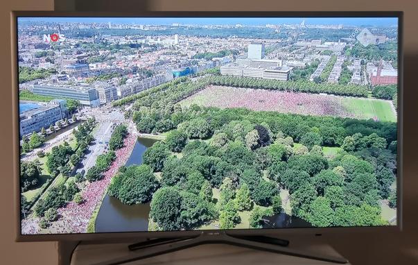Aerial view of massive red crowd on field and street
