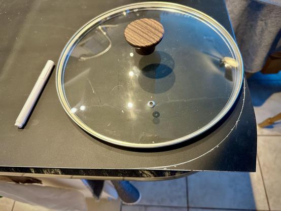 To cut the black mat to a rounded corner on granite countertop surrounding the sink I traced around the right size pan cover with the white marker shown left.