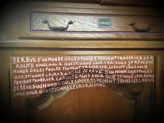 Phrase écrite sur une armoire en bois: "Je #rêve d'un monde où les #poules peuvent traverser la route sans questionné leurs raisons"