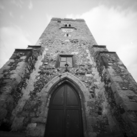 Photograph looking up from the ground at the front of a medieval church.