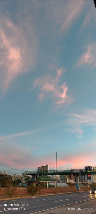 Céu azul com nuvens rosas.