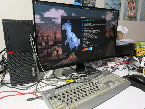 The PC on my desk, the monitor is showing the fastfetch screen with the PC tower itself on the left