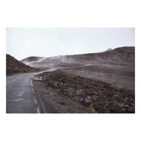 road climbing through mountain pass with mist highlighting the geology