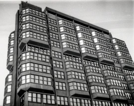 A black and white grainy image of a brutalist style towerblock