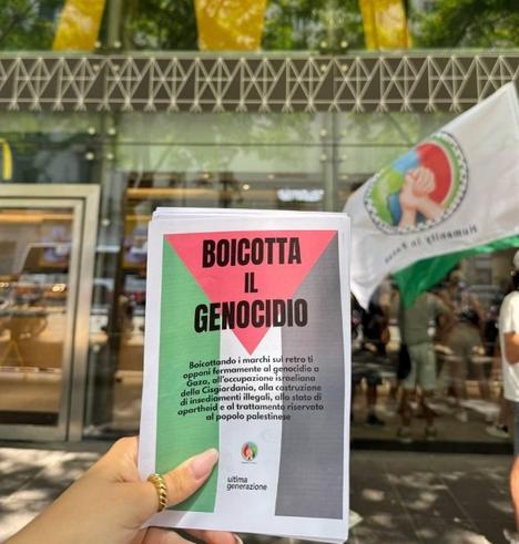 Volantino, fronte.

Sullo sfondo una bandiera palestinese. Il titolo riporta "Boicotta il genocidio". Poi la scritta: "Boicottando i marchi sul retro ti opponi fermamente al genocidio a Gaza, all'occupazione israeliana della Cisgiordania, alla costruzione di insediamenti illegali, allo stato di apartheid e al trattamento riservato al popolo palestinese.