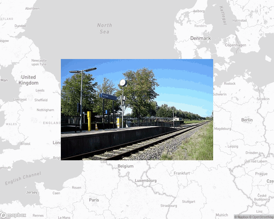 A photo of or from a train station from the linked website, overlaid on a cropped world map where it's located.