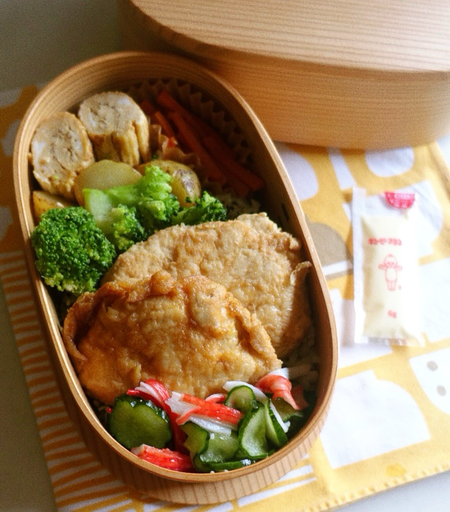 わっぱ弁当箱に詰められた甘い卵焼き、人参きんぴら、新じゃがの煮物、ブロッコリー、チキン南蛮、胡瓜とカニカマ の甘酸っぱい和えが写っている。