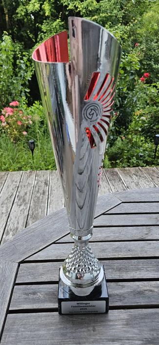 Hoher Pokal auf Gartentisch.