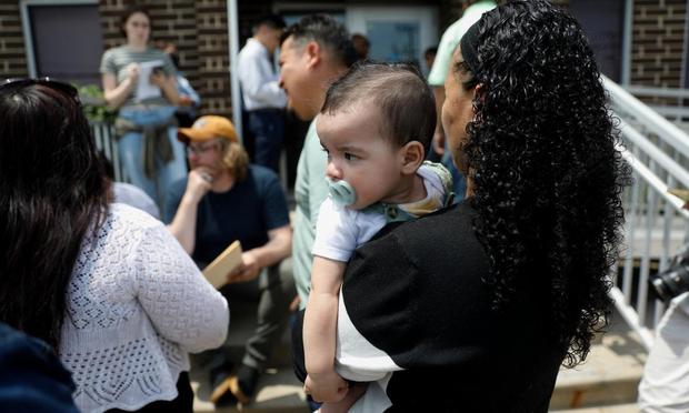 Claudia Núñez sostiene a su hija, Arisbeth, mientras su esposo Yoni habla con un abogado antes de ir a una citación del ICE, el 15 de junio de 2025 en Chicago. (Octavio Jones / Reuters)