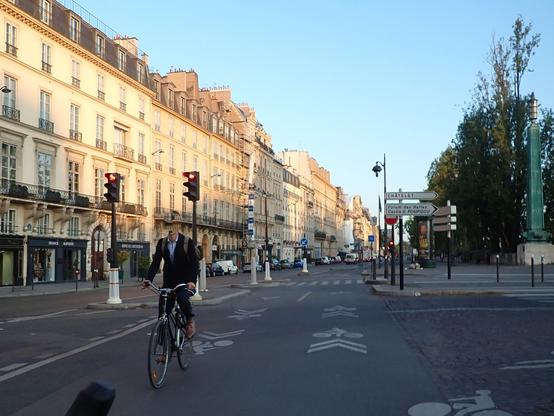 Cycliste en chemise, veste, chaussures en cuir, sur une vélo de ville