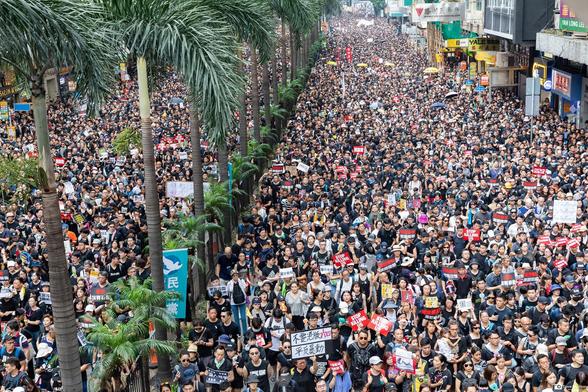 A huge crowd among the 2 million plus 1 marching through Wanchai wearing black t-shirts.